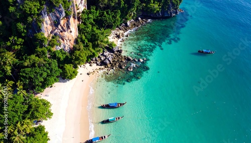 Aerial view of boats resting on a tropical sandy beach with lush vegetation bordering turquoise waters