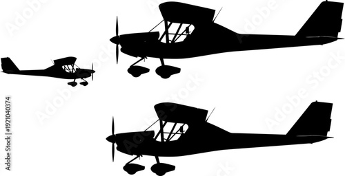 Small light propeller aircraft silhouettes in flight