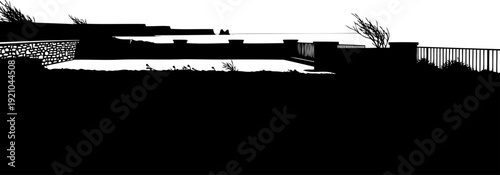 Coastal overlook with stone wall and ocean view silhouette