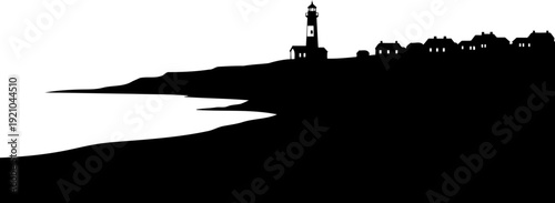 Coastal lighthouse silhouette standing near small village houses on shoreline