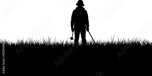 Figure of a person standing in a meadow with equipment