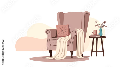 Comfortable wingback armchair in a cozy living room setting with a warm blanket, a decorative pillow, and a small side table holding books and tea.