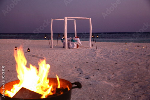 Fotografija Romantic Beach Wedding Setup with Bonfire at Maldives Sunset