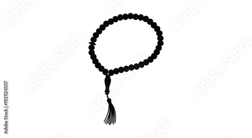 A black prayer bead necklace with a tassel is displayed against a plain white background a striking silhouette
