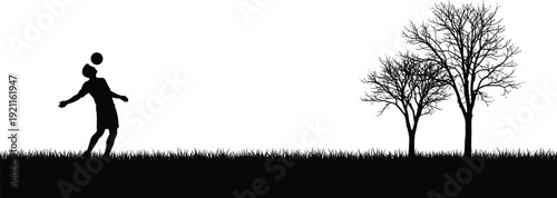 Silhouette of a Person Kicking a Ball with Bare Trees in Background