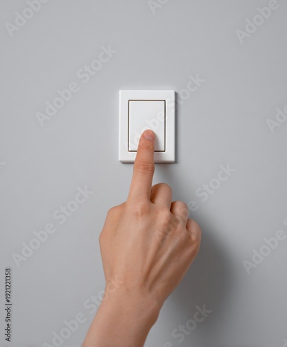 Hand activating light switch home interior action photography minimalist design close-up view daily life concept
