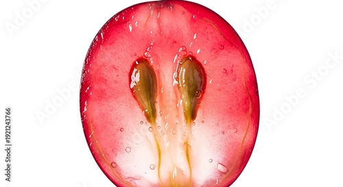 Closeup macro view of a red grape cut in half revealing seeds and juicy pulp.