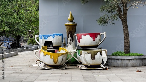 Fotografie A collection of giant, colorful teacup sculptures with a dripping paint effect in a public park
