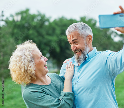 Wallpaper Mural Happy active mid aged couple taking selfie in park or in nature outdoors. Love togetherness and acive seniors vitality concept Torontodigital.ca
