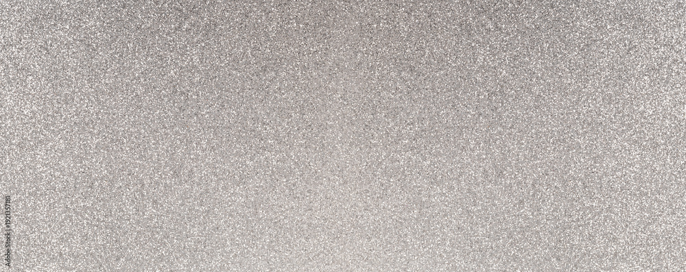 Fototapeta premium Silver glitter texture reflecting light on surface