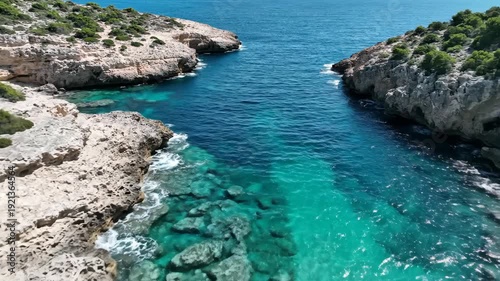 Scenic coastal landscape with clear turquoise water flowing between rocky cliffs and greenery, highlighting the natural beauty of a Mediterranean environment