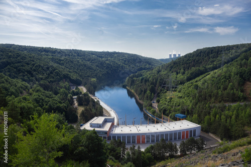 Large architectural complex of the hydroelectric power plant building located at the base of the Dalesice dam reservoir with Dukovany nuclear power plant in background