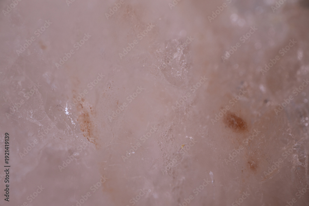 Fototapeta premium Close-up view of a translucent quartz crystal with visible inclusions and natural patterns, showcasing its unique texture and mineral composition in a natural setting