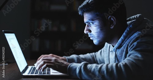 Focused individual working late at night on a laptop, illuminated by screen light in a cozy room