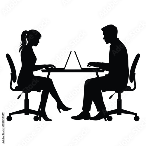 Two professionals collaborate at a desk with a laptop in silhouette