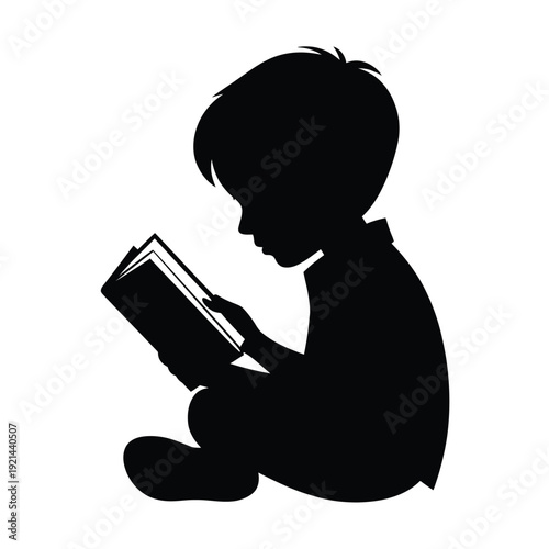 A young boy is deeply engrossed in reading an open book