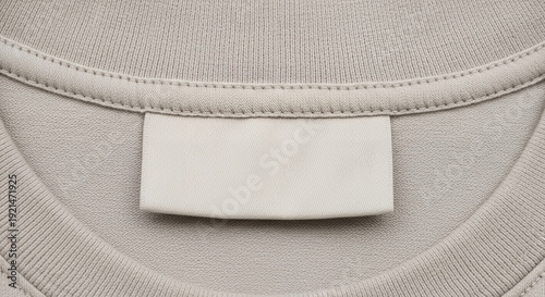 Blank clothing label on neutral fabric background, copy space