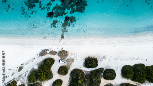 Camper van parked on Cala Banana beach, aerial top view, Sardinia, Italy.