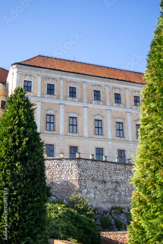 Close-up view of Mikulov Castle facade behind tall cypress trees