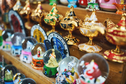 Photography Moroccan souvenir shop display with golden teapots and snow globes
