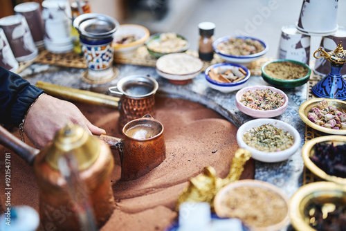 Traditional Turkish coffee brewing in hot sand with herbs and spices