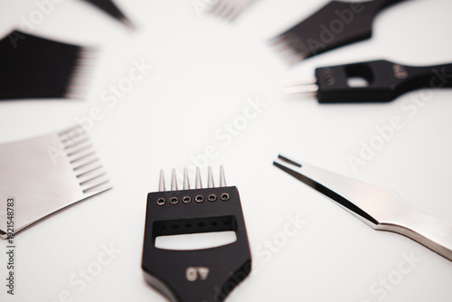 Macro photography of black metal leatherworking pricking irons and stitching punches arranged in a radial circle with selective focus and copy space.