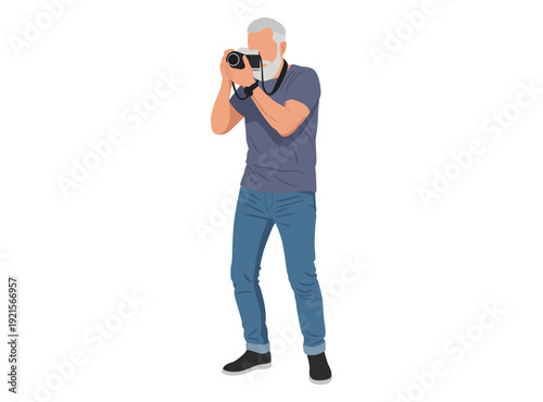 mature man with a white beard taking a photo. He wears a grey t-shirt and blue jeans, holding a professional DSLR camera