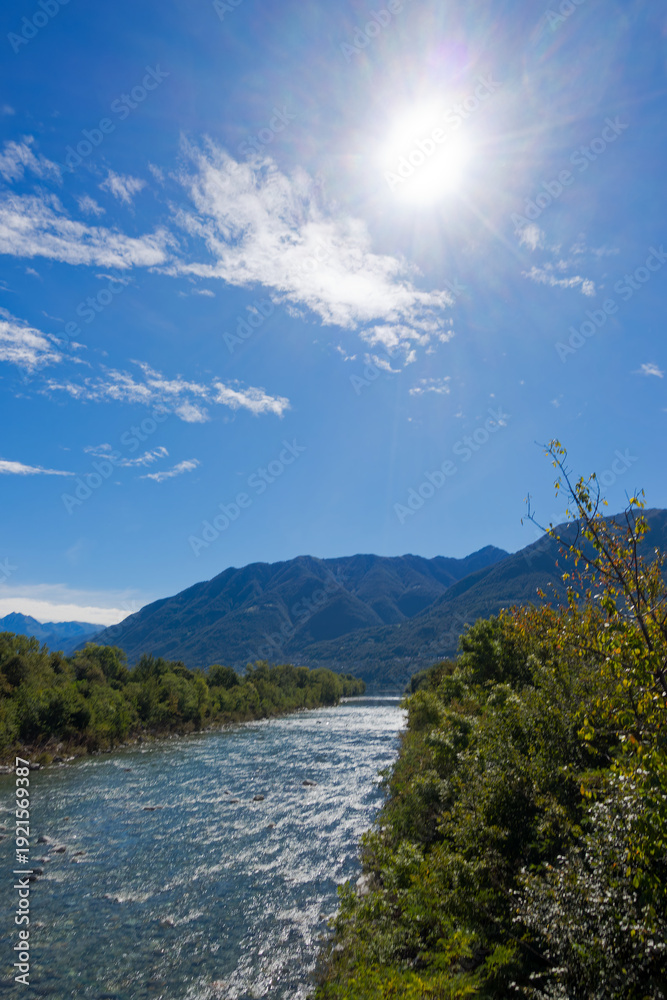 Obraz premium Scenic view from bridge between Ascona and Locarno with Maggia River and Lago Maggiore lake in the background on a sunny summer day. Photo taken September 3rd, 2025, Ascona Locarno, Switzerland.