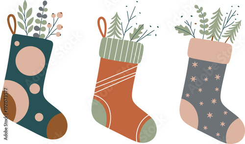 Three colorful christmas stockings with plants on white background