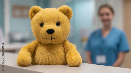 Hospital reception area, A plush teddy bear sits on a counter with a blurred medical professional wearing scrubs in the background.
