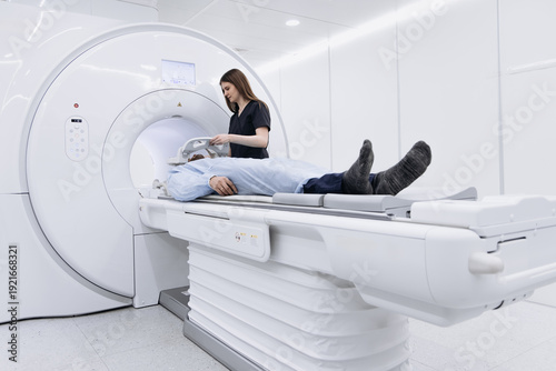 Foto Physician checking patient position and safety before tomography