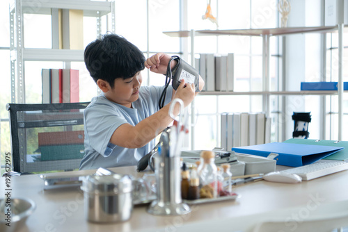 Wallpaper Mural Young boy exploring blood pressure monitor in medical examination room Torontodigital.ca
