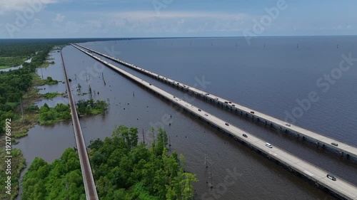 Cars Traveling on raised highway over Louisiana Lake Ponchartrain beside natural wetland bayou at Good Hope, LA