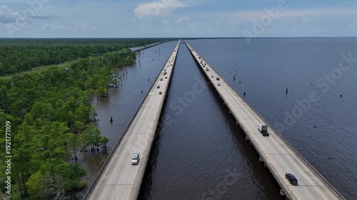 Cars Traveling on raised highway over Louisiana Lake Ponchartrain beside natural wetland bayou at Good Hope, LA