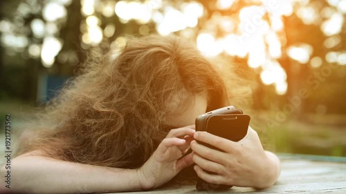 Wallpaper Mural Little girl lies and looks at smartphone Torontodigital.ca