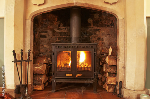 wood burner with burning logs in large open fireplace