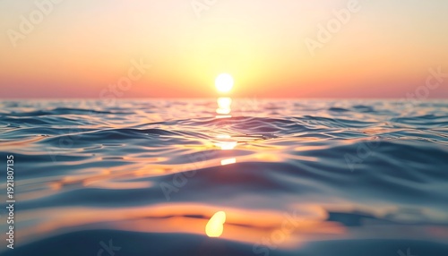 Ocean waves at sunset with a bright sun and pink sky reflecting on water