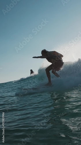 Stylish surfer. Young man in bright colorful shirt surfs the wave. Speed warp effect applied with frozen movement of the rider