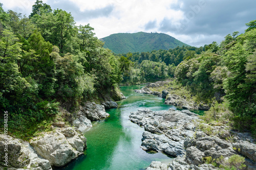 Photos Pelorus River in New Zealand, featuring vibrant turquoise water flowing through a rocky landscape surrounded by lush green forests and hills