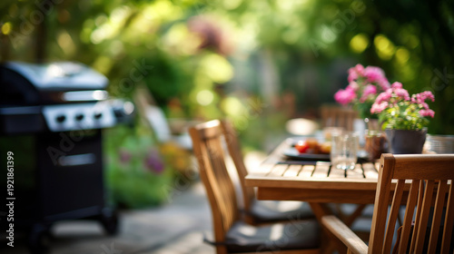 Summer time in backyard garden with BBQ grill and wooden table blurred background outdoor entertaining setup patio lifestyle cooking area warm season heavily defocused