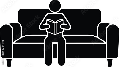 Person reading book on sofa silhouette icon representing education, leisure, and home study concept