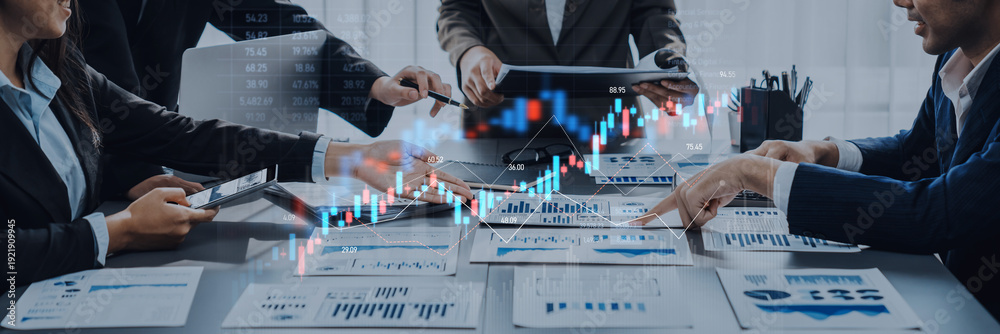 Obraz premium A business team discusses financial graphs and data during a meeting, showcasing modern technology and focusing on market trends for informed decision-making. Trope