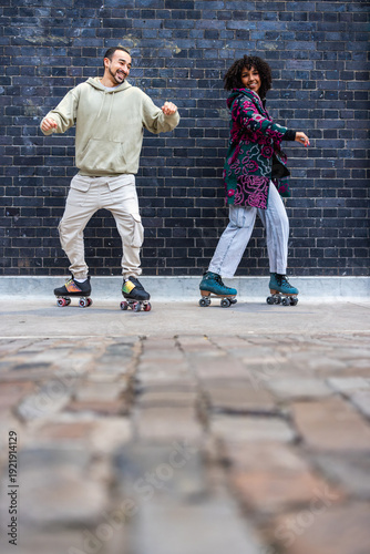 Young couple roller skating, enjoying leisure activity outdoors