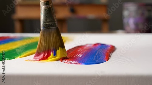 Closeup shot of a paintbrush applying vibrant colors onto a white canvas