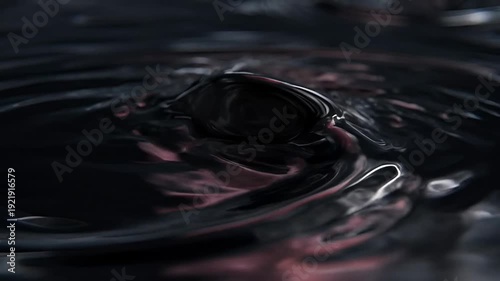 Abstract swirling black liquid surface with subtle reflections and dark undertones