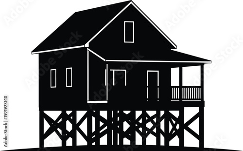 A black and white image of a house on stilts with a porch