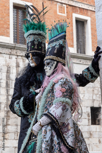 Elegant Masked Couple in Period Costumes by the Canal During Venice Carnival
