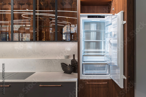 Tableau sur toile Open refrigerator near marble countertop with induction hob