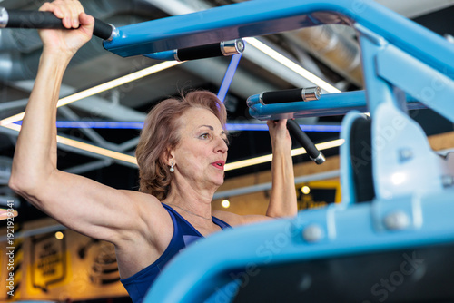 Tablou pe pânză Active Senior Woman Training on Lat Pulldown Machine in Modern Gym