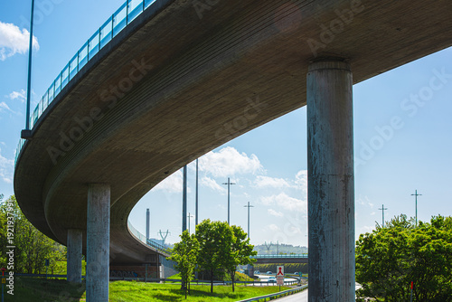 Foto Curved highway overpass bridge with concrete pillars in daylight.